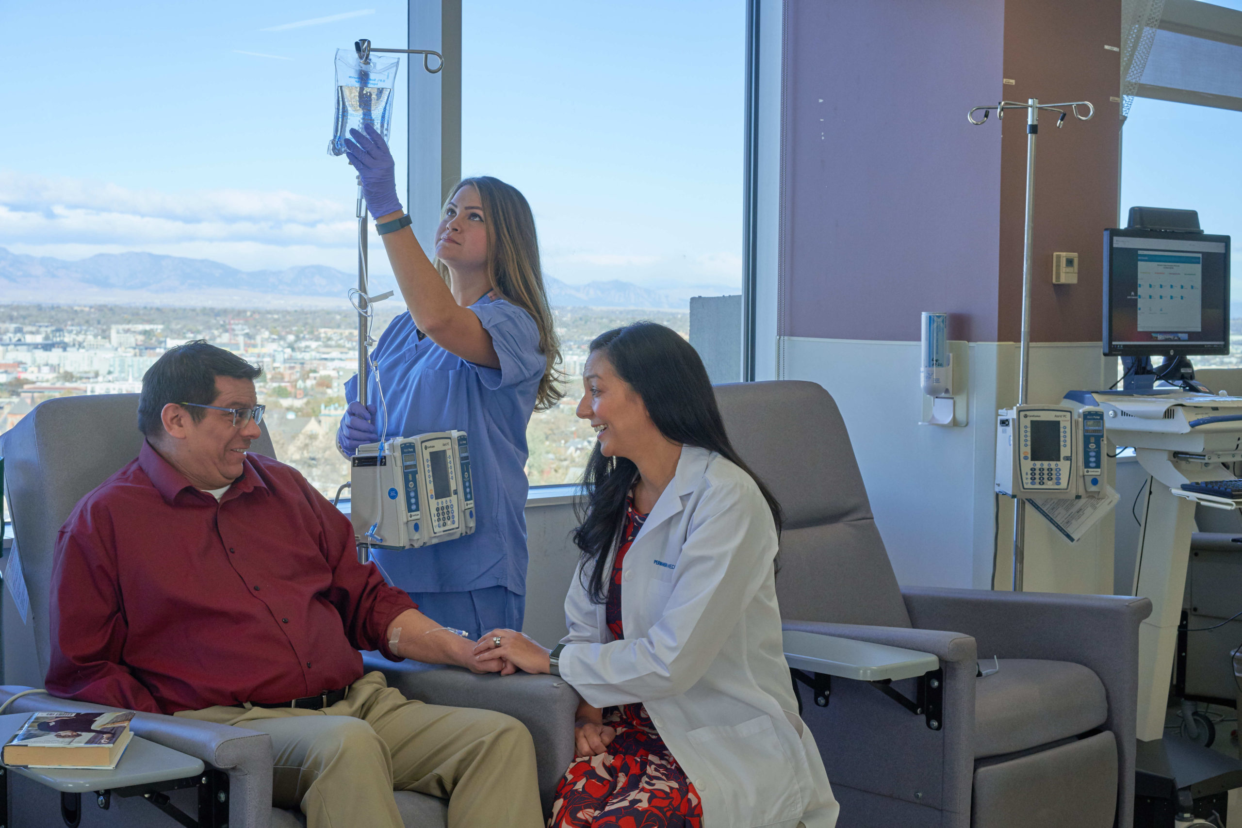 Male patient receiving IV from female physician and female nurse.