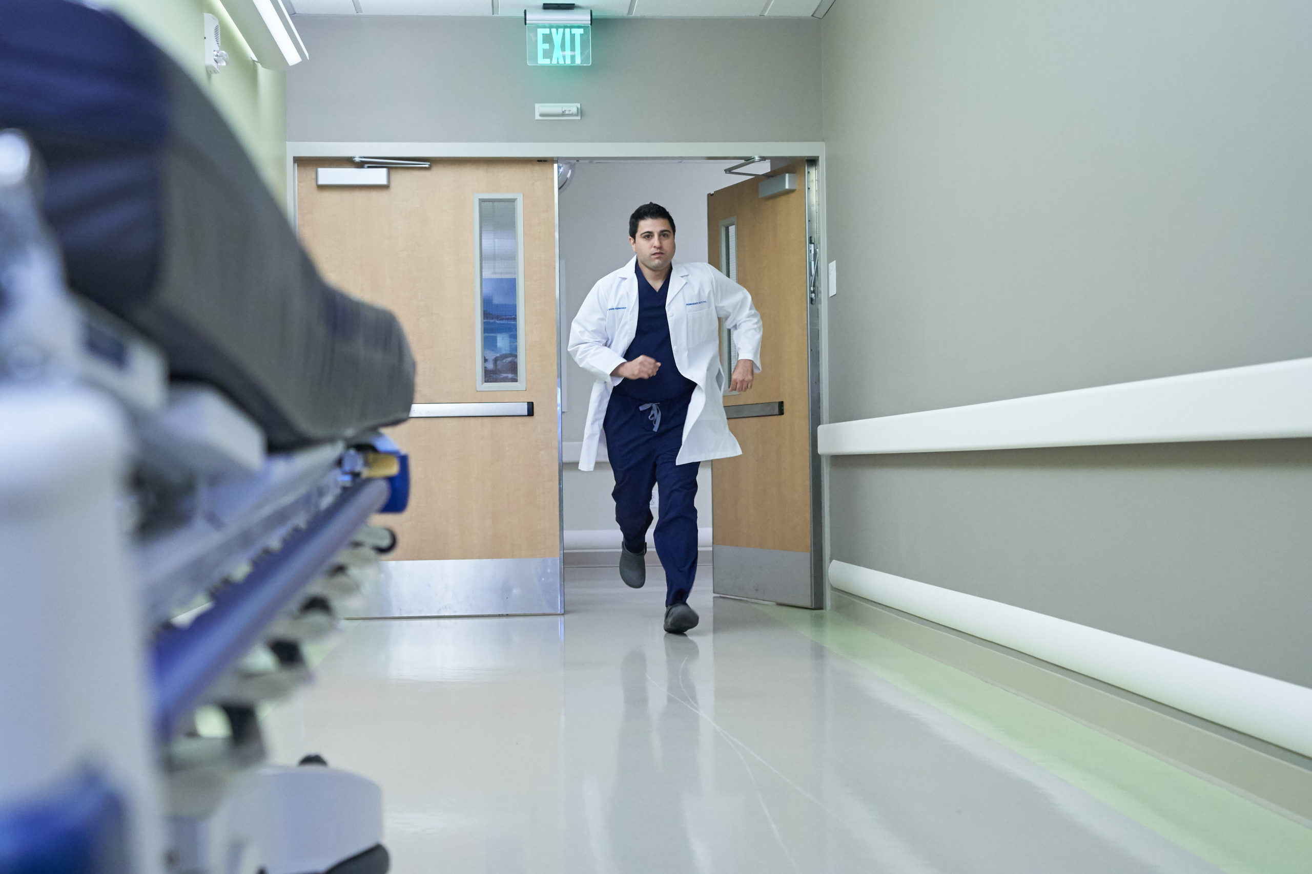 Emergency room physician running through medical center door