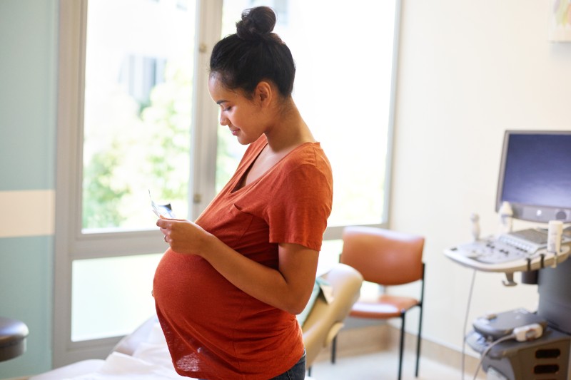 Pregnant Black woman standing in doctor's office