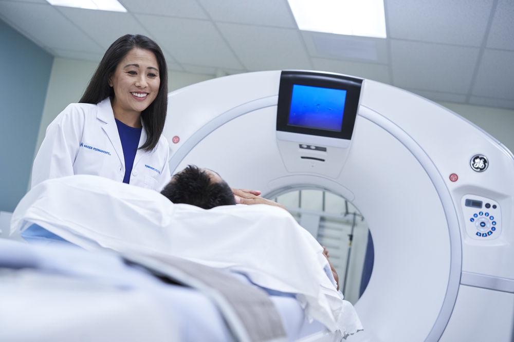 Female doctor caring for male patient undergoing a CT scan