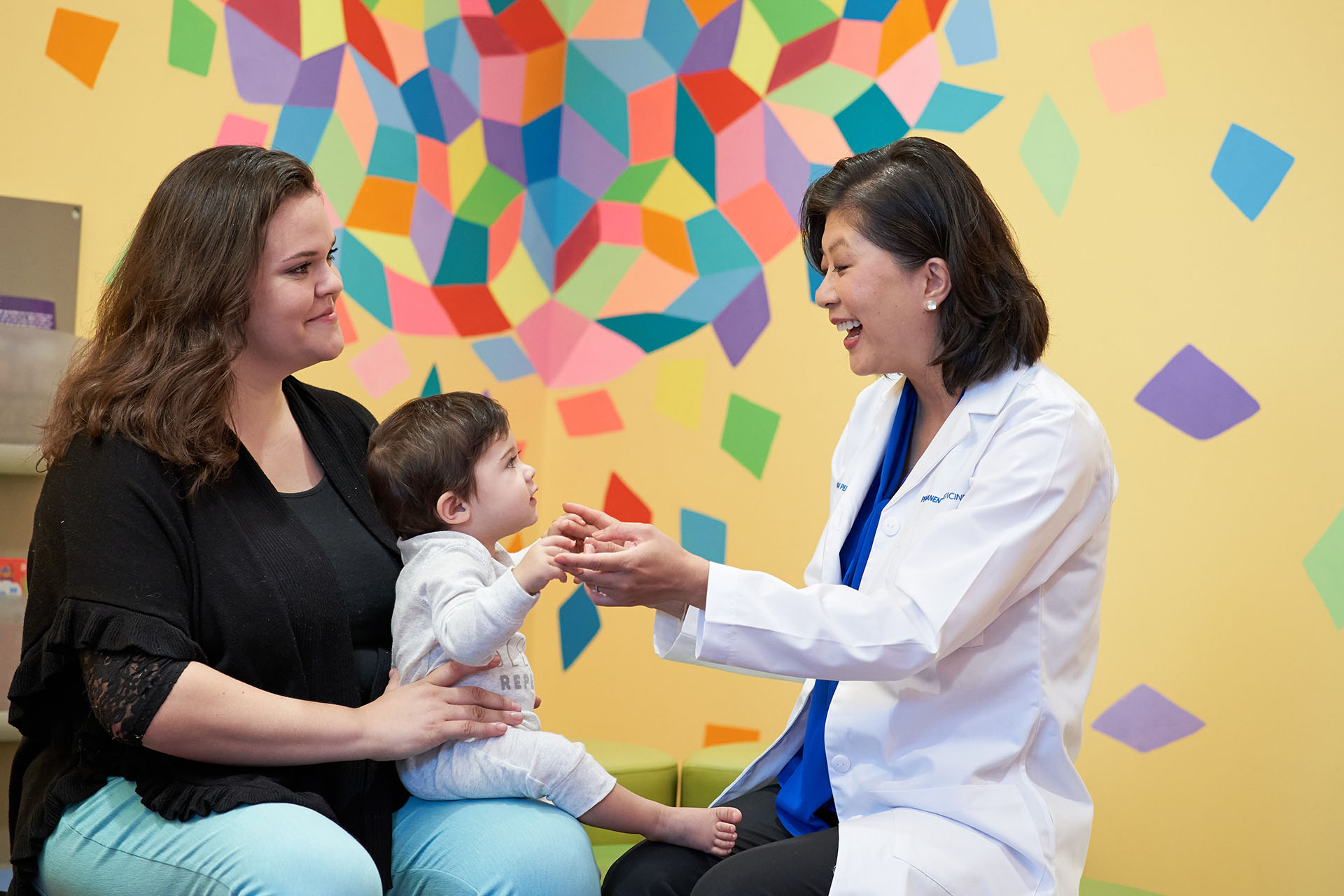 Physician treating child patient in parent's lap.