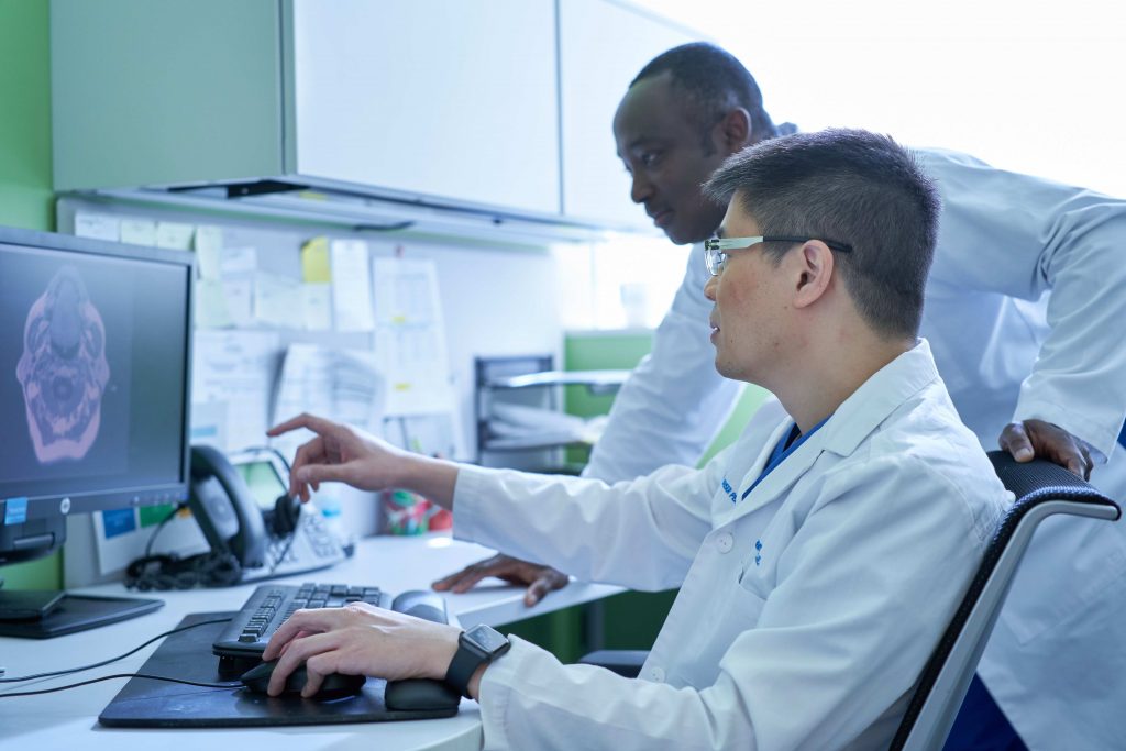 Two Permanente physicians confer while examining X-ray.